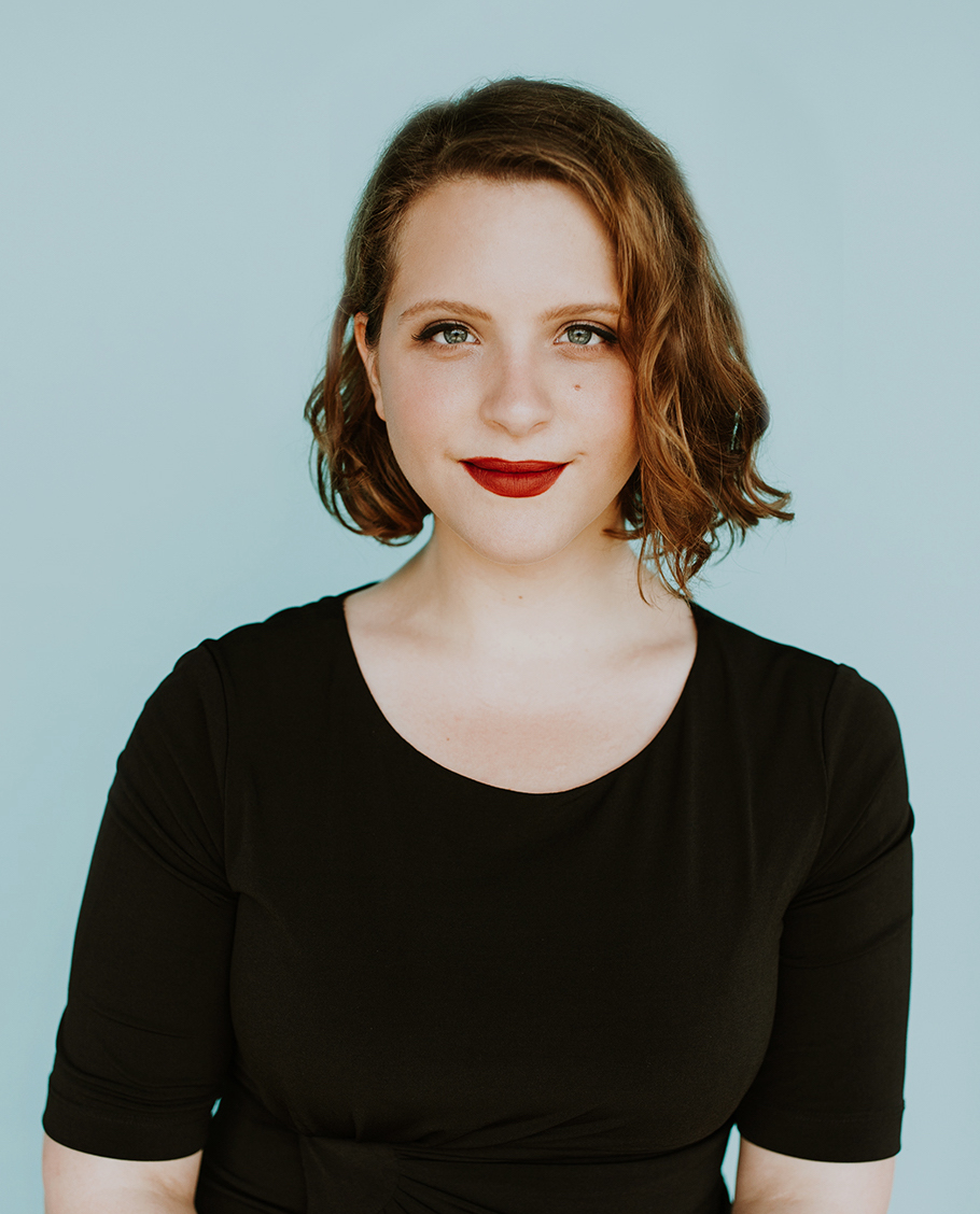 Soprano Jardena Gertler-Jaffe, from the waist up, looking straight at the camera with a half-smile. She has a short wavy bob and is wearing a black dress and red lipstick.