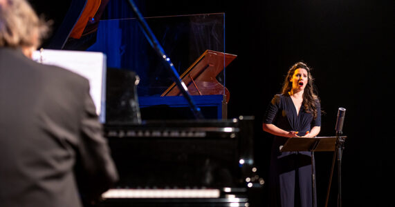 Photo of Mireille Asselin and Frederic Lacroix by Dahlia Katz Mireille Asselin singing, from the perspective over pianist Frederic Lacroix's shoulder